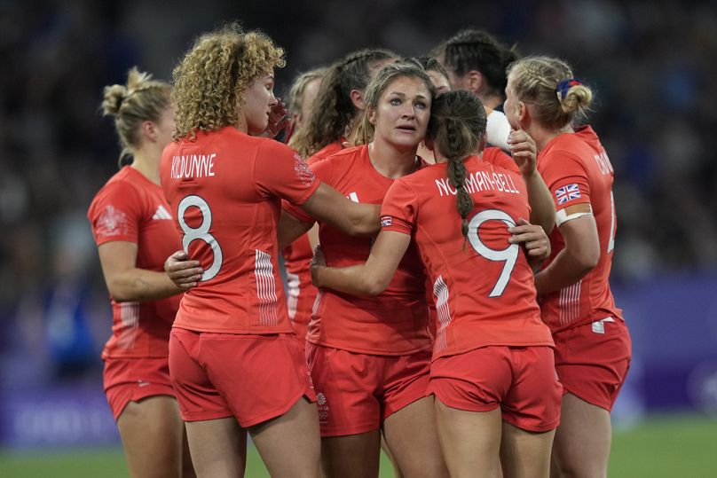 Great Britain's Amy Wilson Hardy, center joins her teammates in a huddle after they lost their women's quarterfinal Rugby Sevens match between Great Britain and the US