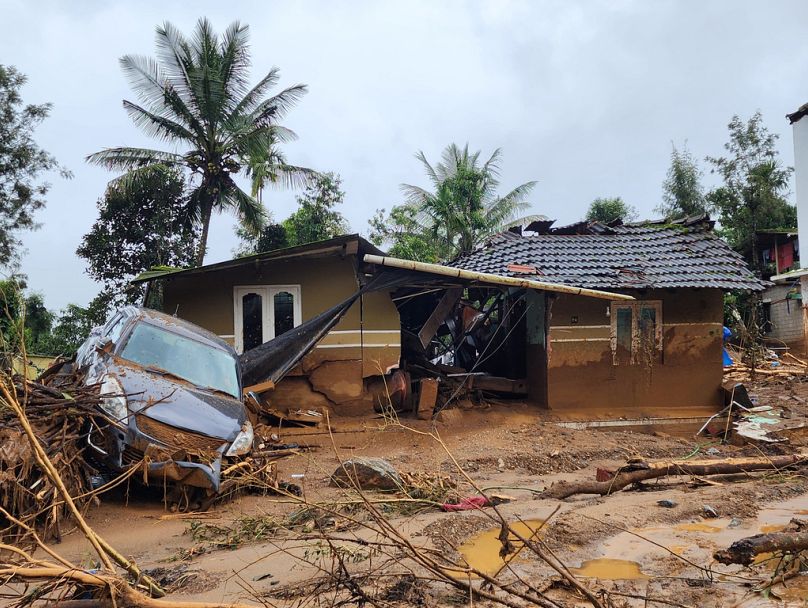 A damaged car and a house after landslides hit hilly villages in Wayanad district, Kerala state, India, Tuesday, July 30, 2024. 