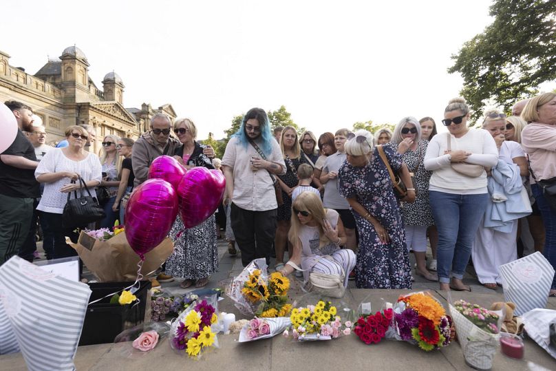 Members of the public take part in a vigil near the scene in Hart Street, in Southport, England on Tuesday