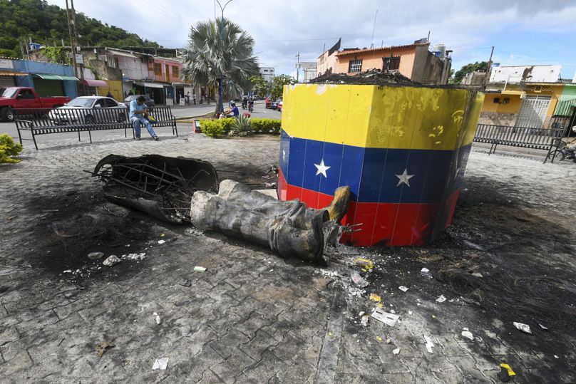 Una statua distrutta dell'ex presidente venezuelano Hugo Chávez accanto alla sua base a Valencia, in Venezuela