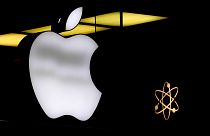The Apple logo is illuminated at a store in Munich, Germany