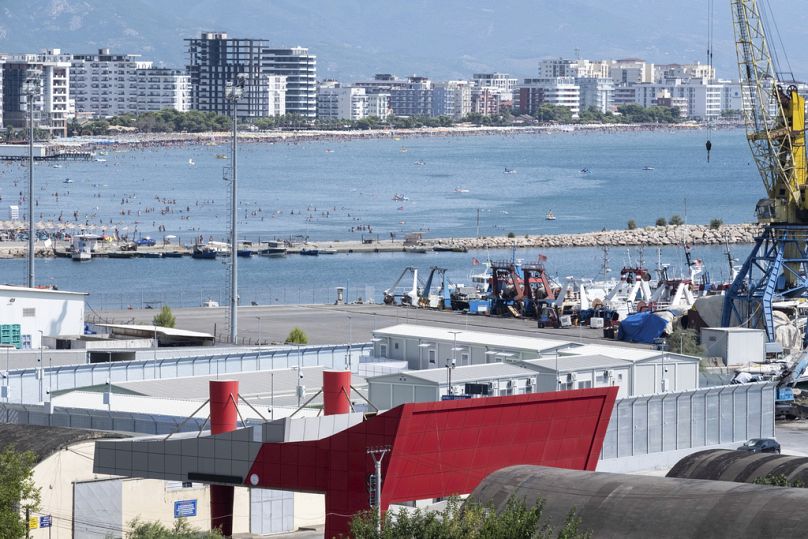 People gather on the beach near a migrant centre in the port of Shengjin, northwest Albania.