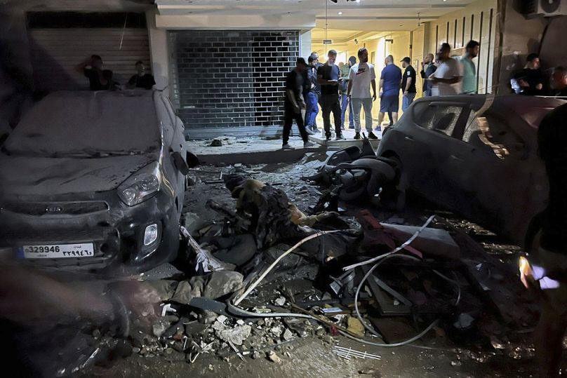 People inspect damaged cars in the southern suburbs of Beirut, Lebanon, Tuesday, July 30, 2024.