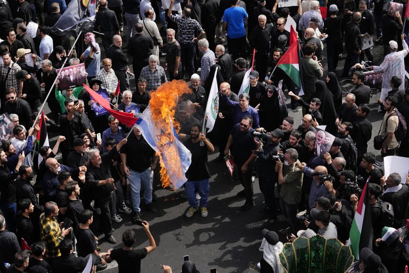 Iranians burn a representation of the Israeli flag during the funeral ceremony of Hamas leader Ismail Haniyeh and his bodyguard on Thursday