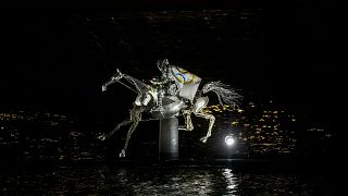 A performer on a mechanical horse carries the Olympic flag down the river Seine in Paris, France, during the opening ceremony of the 2024 Summer Olympics, July 26, 2024.