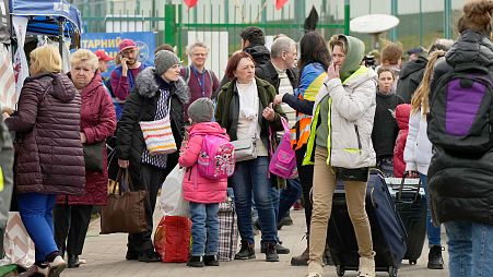 ARCHIVO - Refugiados esperan en fila tras huir de la guerra de la vecina Ucrania en el paso fronterizo de Medyka, al sureste de Polonia, el 7 de abril de 2022.