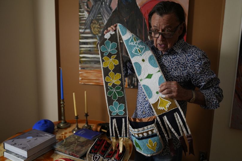 Joe Baker, a member of the Delaware Tribe of Indians and co-founder of the Lenape Center, holds one of his handmade bandolier bag during an interview in his home in New York.