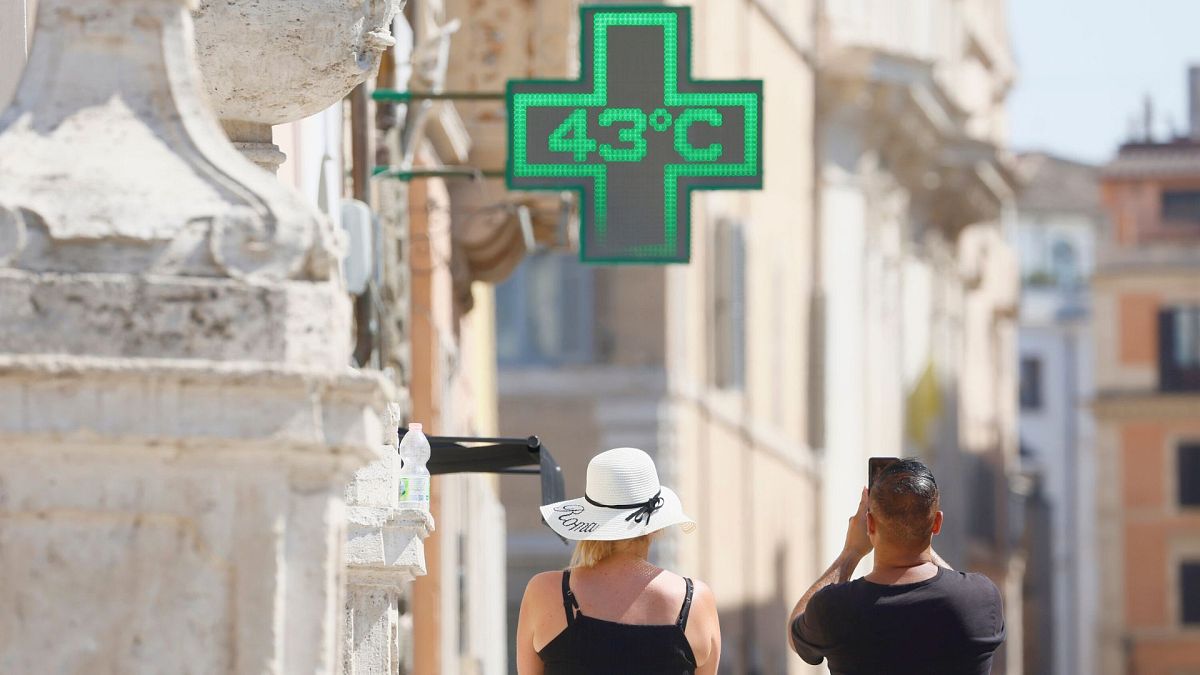 Un hombre toma una foto de la temperatura de 43 grados C registrada al sol en el exterior de una farmacia en Roma, 11 de julio de 2024. 