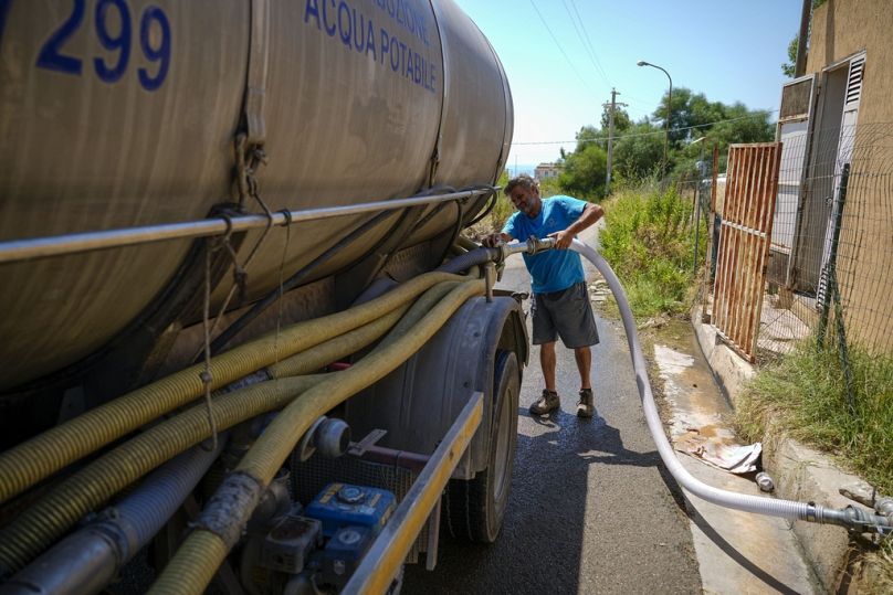  Un uomo riempie un'autobotte per il trasporto dell'acqua, 18 luglio 2024, Agrigento, Sicily