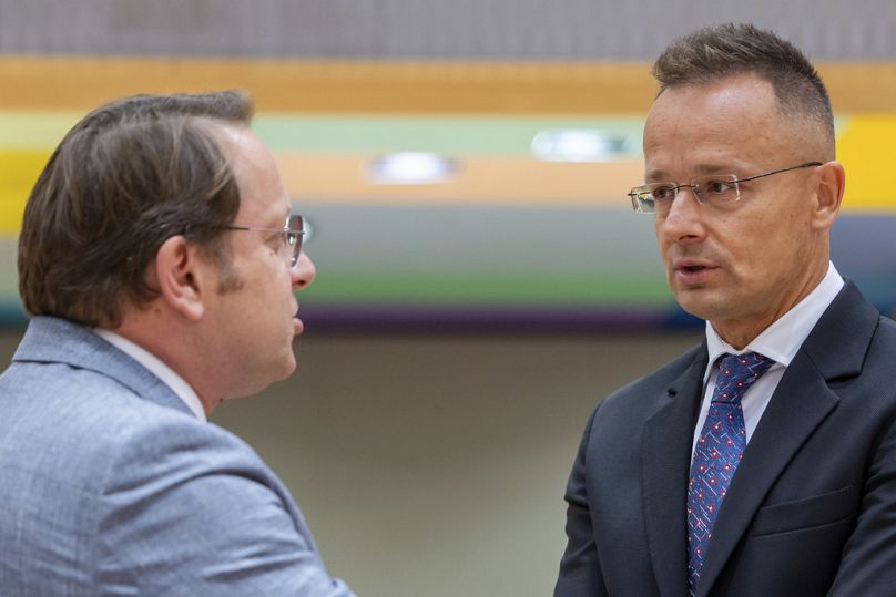 Peter Szijjarto com o Comissário Europeu Oliver Varhelyi, durante uma reunião de ministros dos negócios estrangeiros da UE em Bruxelas, dia 22 de julho 2024.