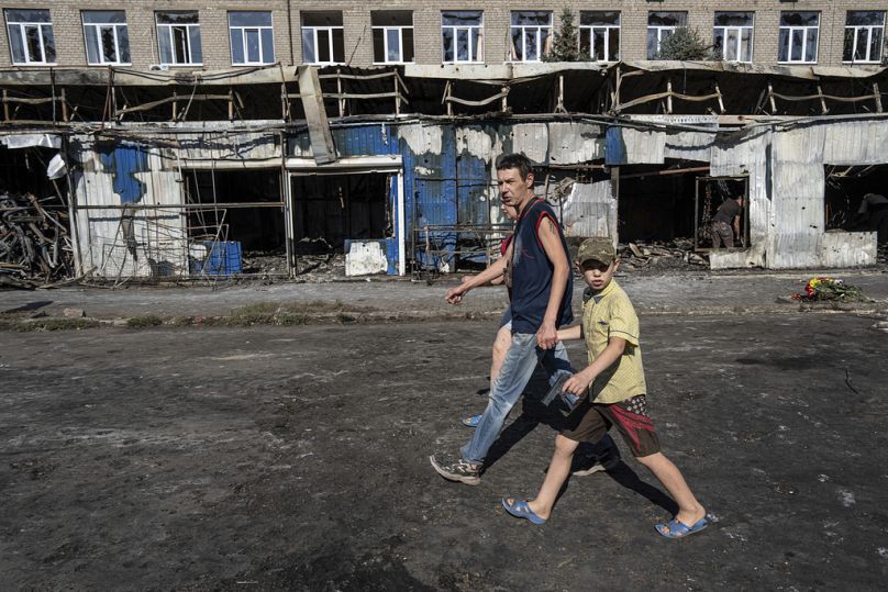 People walk past a destroyed market after yesterday's rocket attack in the city center of Kostiantynivka, Ukraine, Thursday, Sept. 7, 2023