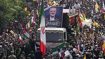 Iranians follow a truck, center, carrying the coffins of Hamas leader Ismail Haniyeh and his bodyguard who were killed in an assassination blamed on Israel on Wednesday.
