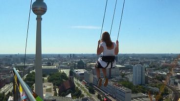 Berliner Fernsehturm mit junger Frau, die ins Bild schwimmt