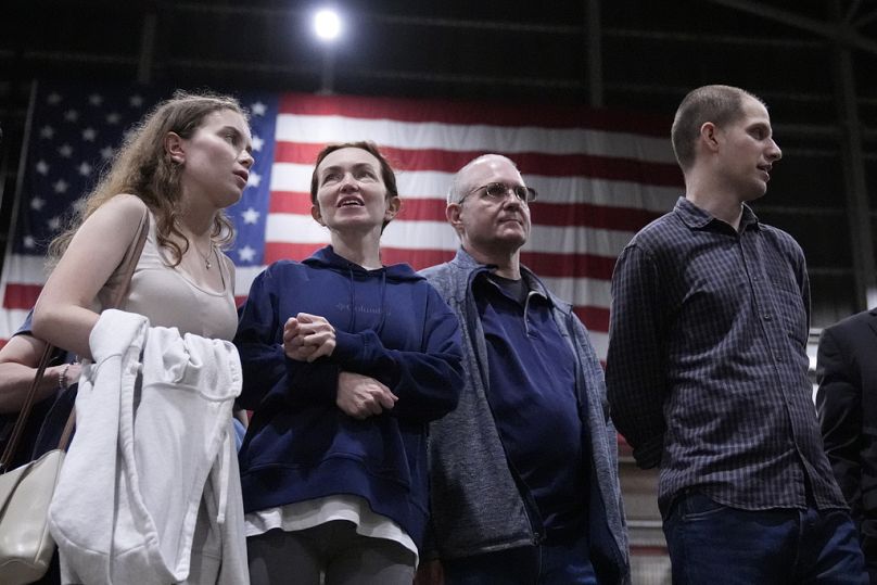 Alsu Kurmasheva, second from left, stands with Paul Whelan, second from right, and Evan Gershkovich, right, after they arrived at Kelly Field after being released by Russia