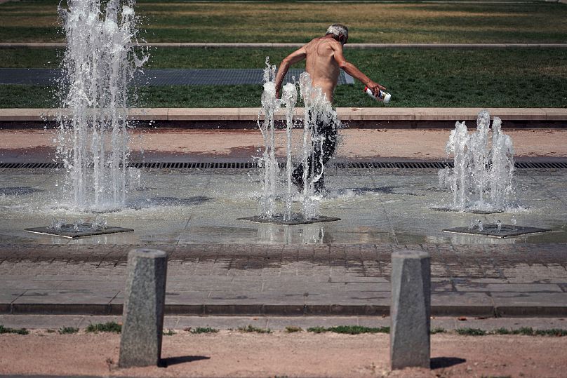 A man cools off in a fountain in Lyon, 24 July, 2019. 