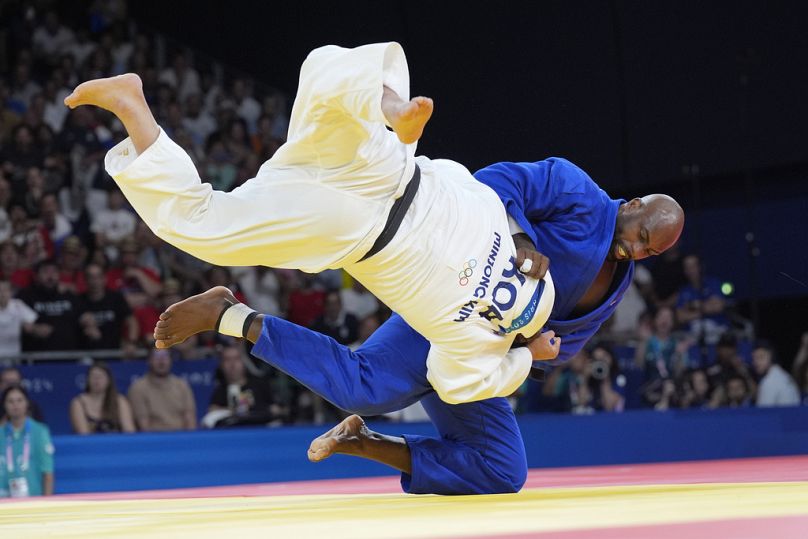 South Korea's Kim Min-jong and France's Teddy Riner compete during their men's +100 kg final match in the team judo competition, at Champ-de-Mars Arena.