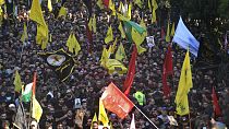 Mourners and Hezbollah fighters carry the coffin of their top commander Fouad Shukur, who was killed by an Israeli airstrike on Tuesday, July 30, during his funeral procession