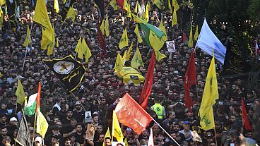 Mourners and Hezbollah fighters carry the coffin of their top commander Fouad Shukur, who was killed by an Israeli airstrike on Tuesday, July 30, during his funeral procession