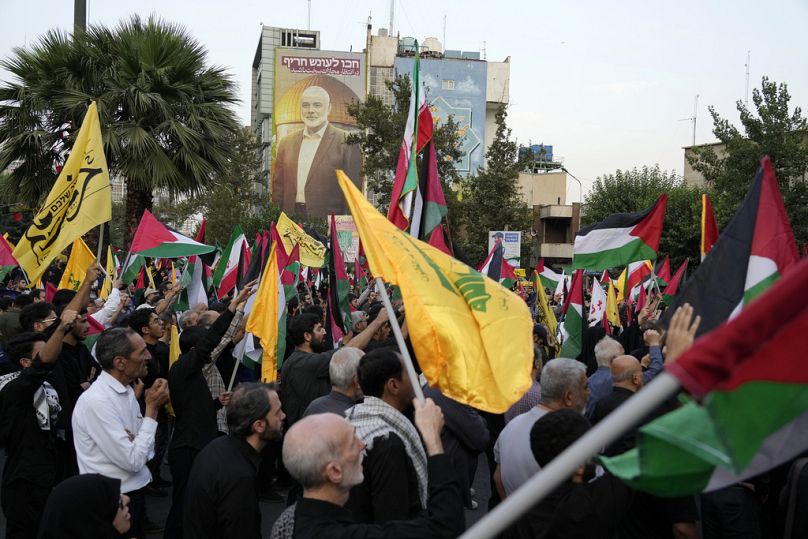 Iranian protesters wave Iranian, Palestinian and Lebanon's militant Hezbollah group flags to condemn the killing of Hamas leader Ismail Haniyeh. July 31, 2024.