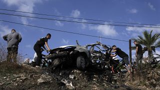 Palestinos alrededor de un coche destruido por un ataque con drones en la aldea de Zeita, al norte de la ciudad cisjordana de Tulkarem, el sábado pasado. 