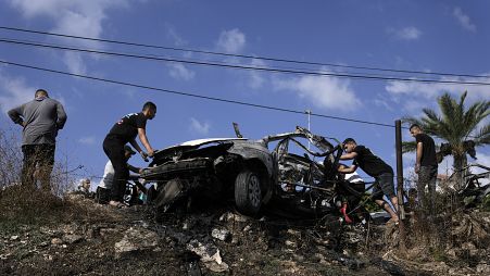 Palestinos alrededor de un coche destruido por un ataque con drones en la aldea de Zeita, al norte de la ciudad cisjordana de Tulkarem, el sábado pasado. 