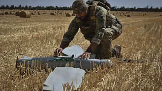 Um soldado da 15ª Brigada da Guarda Nacional da Ucrânia trabalha com um drone de reconhecimento Leleka num campo de trigo para determinar as posições russas.