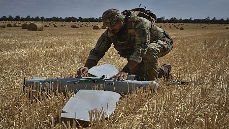 A soldier of Ukraine's National Guard 15th Brigade works with a reconnaissance drone Leleka on a wheat field to determine Russian positions near the front line in Zaporizhzhia