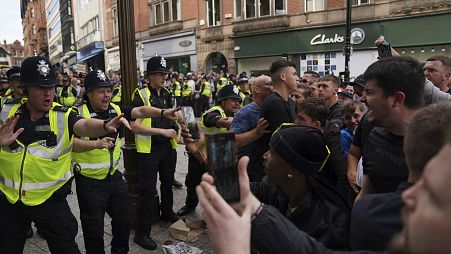 Polizeibeamte stellen sich während einer Demonstration in Nottingham den Demonstranten.