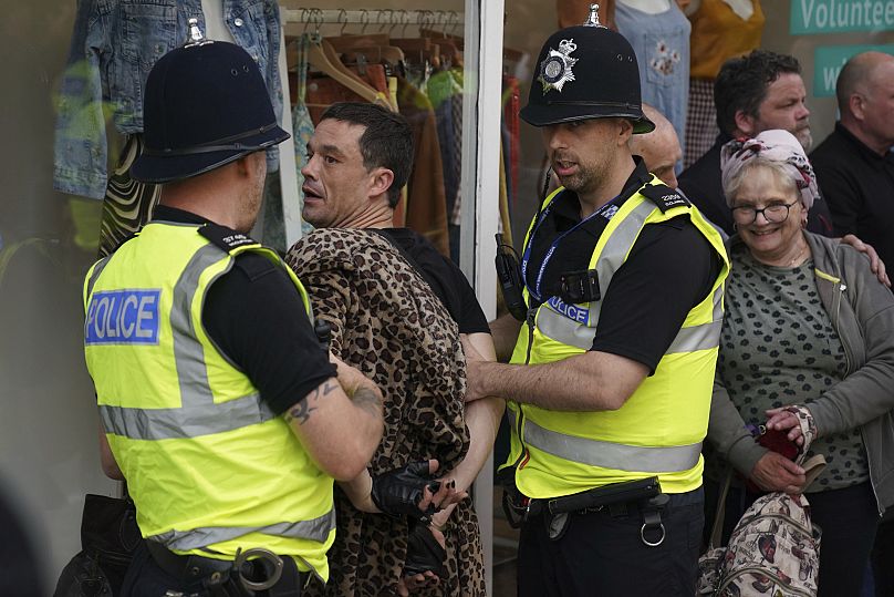 A man is detained by police officers during a protest in Nottingham.