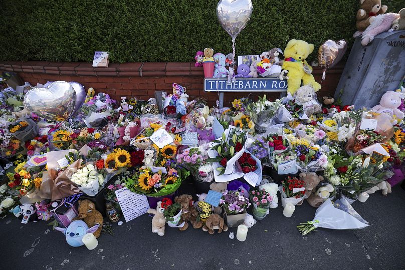 Flowers and toys are placed on the junction of Tithebarn Road and Hart Street in Southport.