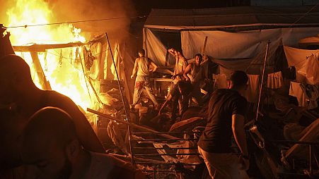 Palestinians react to fire from an Israeli strike that hit a tent area in the courtyard of Al Aqsa Martyrs hospital in Deir al Balah, Gaza Strip on Sunday