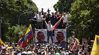 Opposition leader Maria Corina Machado holds a national flag while waving to supporters as she arrives for a rally in Caracas, Venezuela, Saturday, Aug. 3, 2024