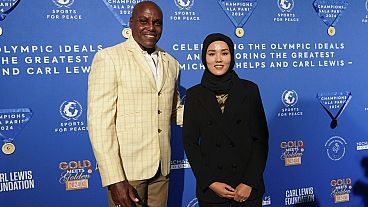 Former Olympian Carl Lewis, left, and representer of the IOC's Refugee Olympic Team Masomah Ali Zada arrives for the Sport for Peace Gala in Paris on Saturday