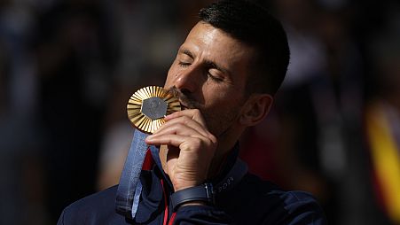 Serbia's Novak Djokovic kisses his gold medal after defeating Spain's Carlos Alcaraz during the men's singles tennis final at the Paris Olympics. Sunday, Aug. 4,