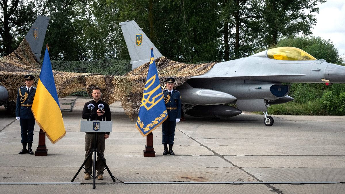 Volodimir Zelenszkij ukrán elnök két F-16-os vadászgép előtt tart beszédet az ukrán légierő napja alkalmából 2024. augusztus 4-én Ukrajnában