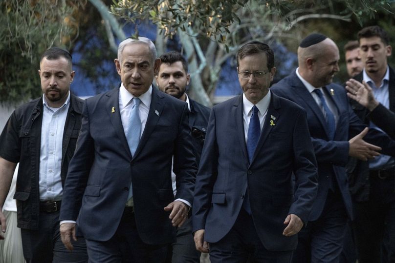 Israeli Prime Minister Benjamin Netanyahu, left, walks with President Isaac Herzog, center right, at Mount Herzl Military Cemetery in Jerusalem, Aug. 4, 2024.