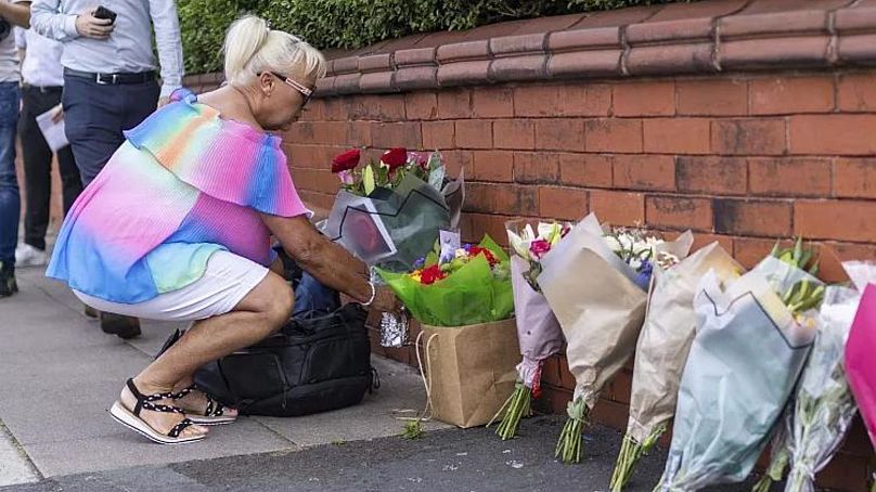 A person leaves flowers near the scene in Hart Street, Southport