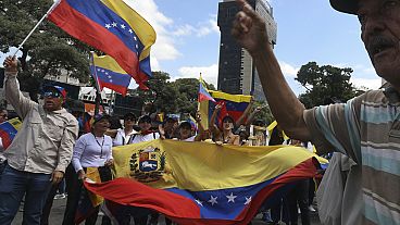 Simpatizantes de la oposición ondean banderas nacionales durante una concentración en Valencia, Venezuela, el sábado 3 de agosto de 2024.