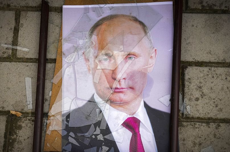 A portrait of Russian President Vladimir Putin lies on the ground near the local prison in Kherson, 16 November 2022