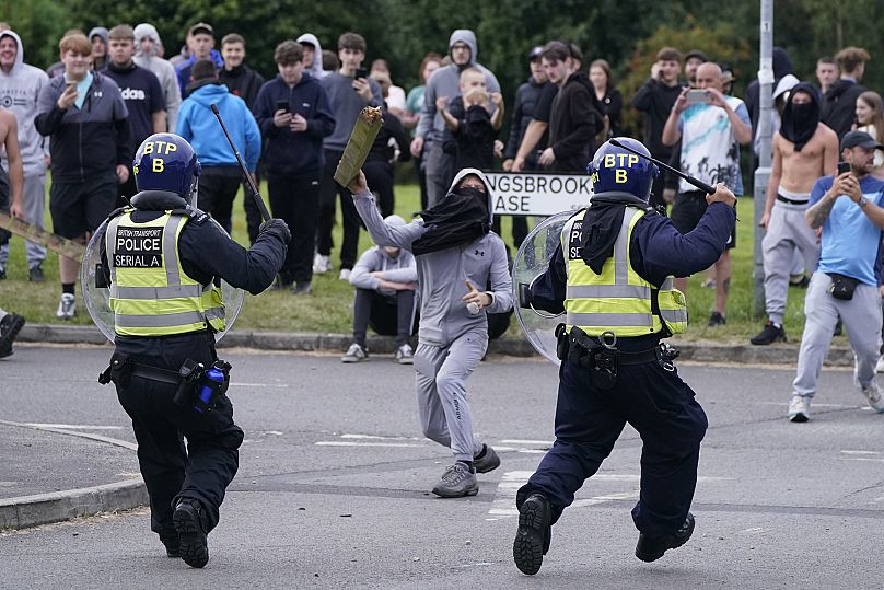 Bir genç, Rotherham'daki Holiday Inn Express otelinin yakınında düzenlenen göçmen karşıtı gösteri sırasında polise direk fırlattı, 4 Ağustos, 2024.