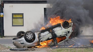 A car burns after being overturned during an anti-immigration protest in Middlesbrough, 4 August 2024