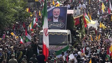 Iranians follow a truck carrying the coffins of Hamas leader Ismail Haniyeh and his bodyguard.