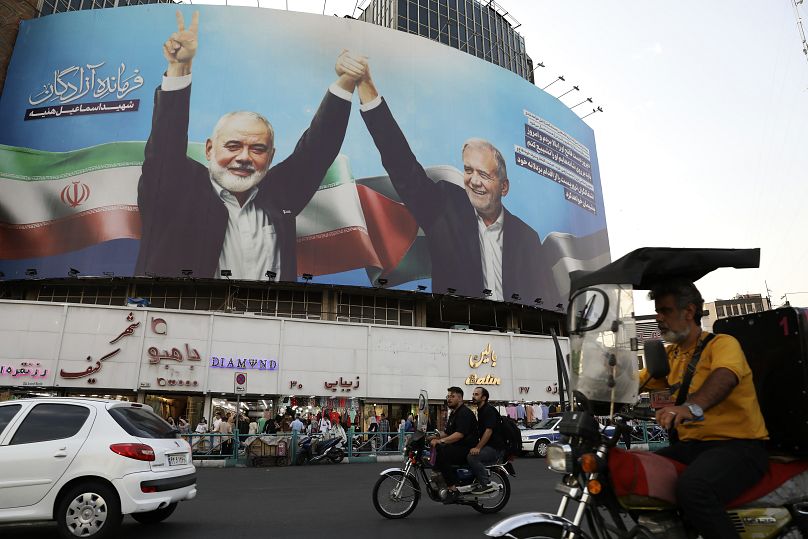 A huge banner shows the late Hamas leader Ismail Haniyeh joining hands with Iranian President Masoud Pezeshkian in Tehran.