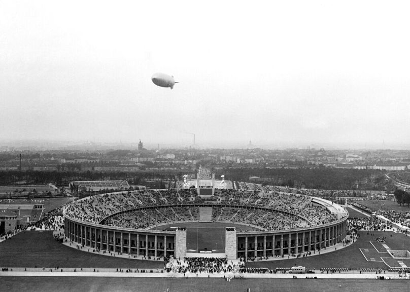 Le dirigeable allemand Hindenburg survole le stade olympique, à l'extérieur de Berlin, le 1ᵉʳ août 1936, lors de la cérémonie d'ouverture des Jeux olympiques. 