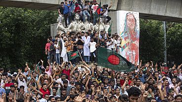Protesters climb a public monument as they celebrate the news of Prime Minister Sheikh Hasina's resignation, in Dhaka, Bangladesh, Monday, Aug. 5, 2024. 