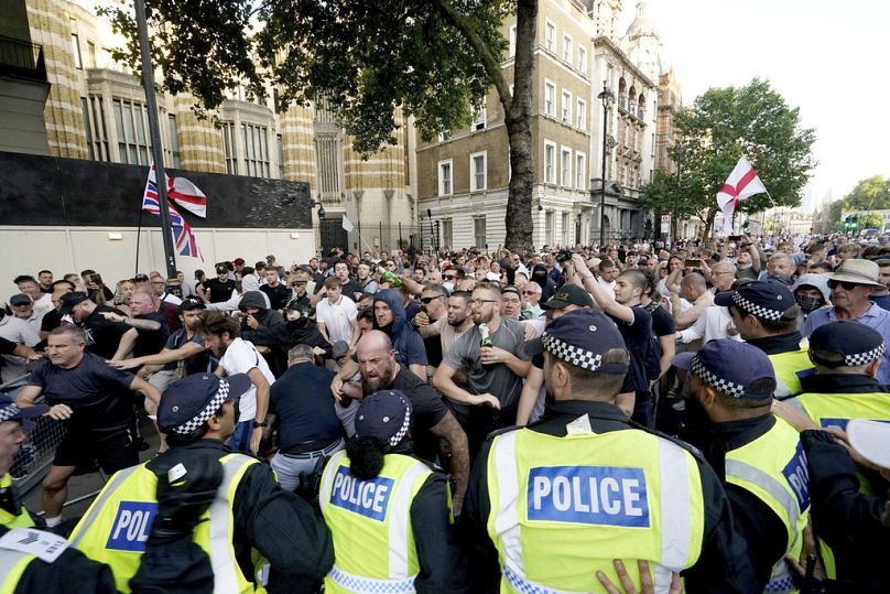 Agentes da polícia entram em confronto com manifestantes durante uma manifestação de protesto "Basta!" em Whitehall, Londres, quarta-feira, 31 de julho de 2024