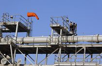 Workers stand on a platform at a Saudi Aramco oil separator processing facility in Abqaiq (file photo)