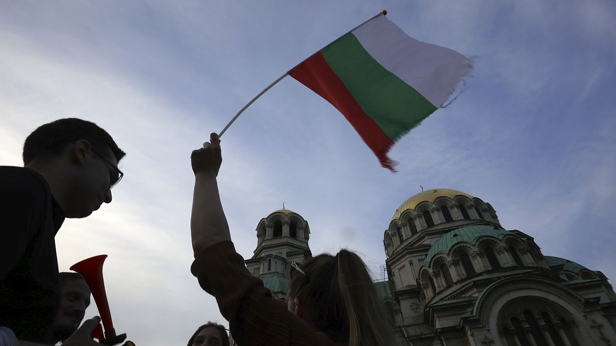 Un ciudadano sostiene una bandera búlgara durante una manifestación en apoyo al Gobierno de Bulgaria en funciones cerca del edificio del Parlamento nacional en Sofía.