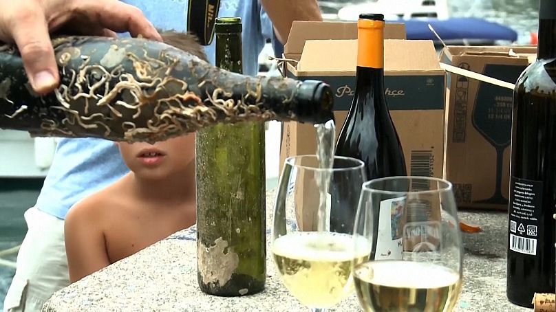 Wine bottle submerged in the sea gets poured into glasses on the Ika bay 