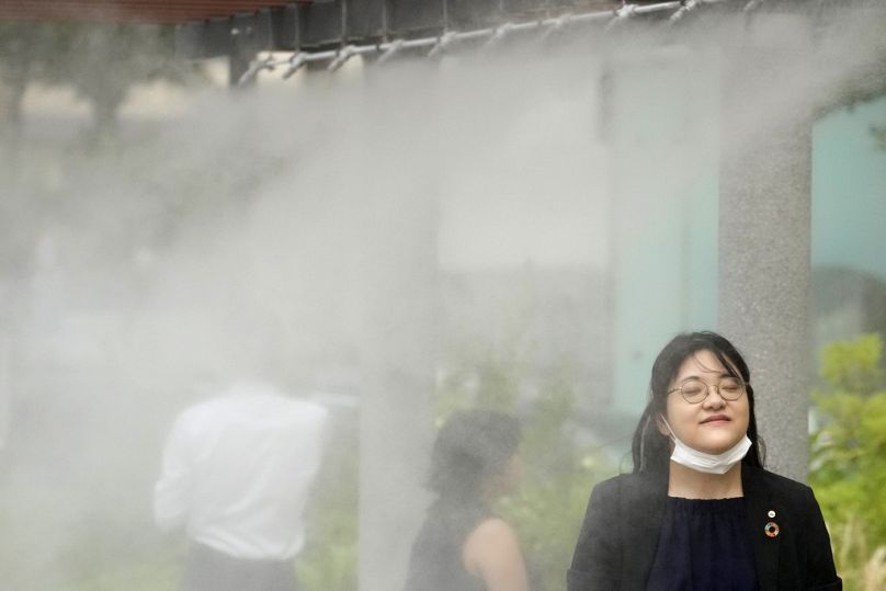 People cool off at a cooling mist spot on July 4, 2024, in Tokyo. 